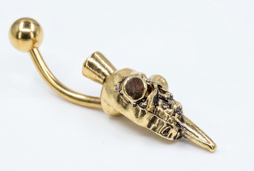Close-up of horned skull belly ring details and polished finish